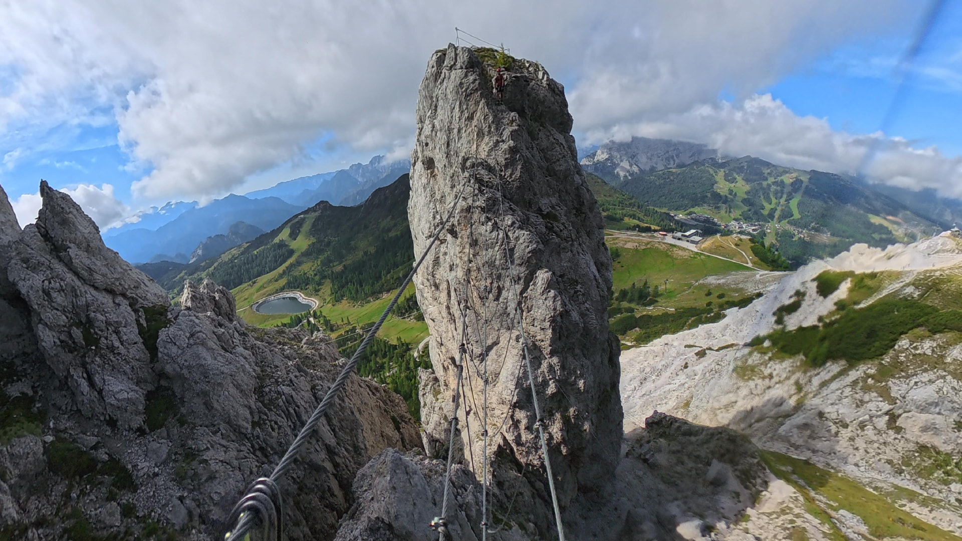 Blick von der Nepalbrücke auf den Däumling-Felsturm mit Kletterin am Gipfel, Nassfeld